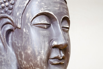 Buddha's face close-up. The Buddha image in ceramics. The texture of the background and focus of the soft focus.