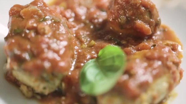 Polpette di pesce impiattate in un ristorante di lusso con basilico e olio extra vergine di oliva e sugo