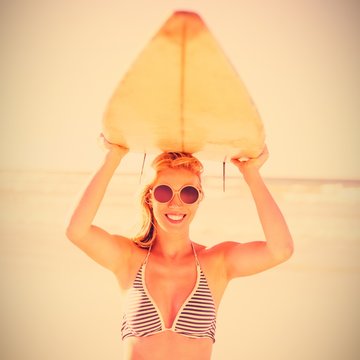 Portrait Of Young Woman Carrying Surfboard At Beach