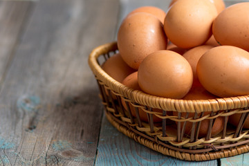 Brown farmers cage-free chicken eggs in basket, close up, rustic table
