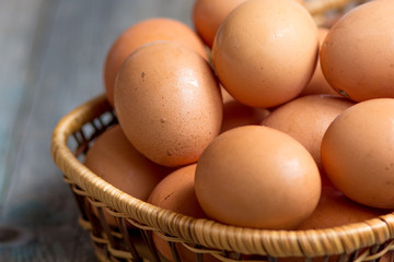 Brown farmers cage-free chicken eggs in basket, close up, rustic table