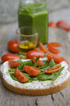 Open sandwich with pesto, rucola, cherry tomato and olive oil

