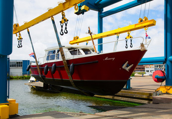 Boat crane lifting a motorboat.