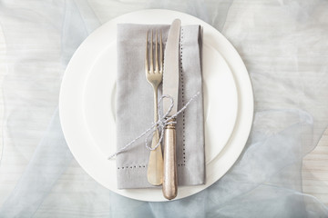 Holiday table place setting with plates, fork and knife, top view