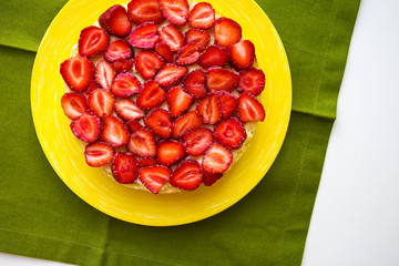 Beautiful strawberry cake is on the table, green napkin.