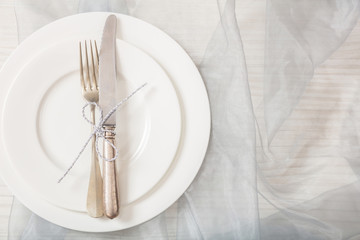 Holiday table place setting with plates, fork and knife, copy space