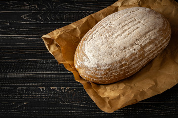 fresh baked bread with tomatoes and garlic with basil on a dark wooden background