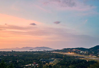 Colourful sunset over airport, mountains and forest on a tropical island      