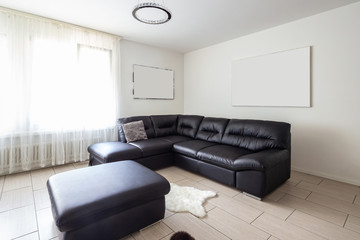Living room with leather sofa and white walls