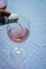 Weingenuss auf Terrasse, Weinglas mit Rose-Wein in Italien, Einschenken