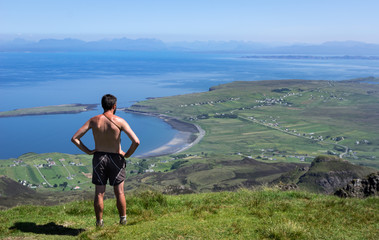 Man Standing at Cliff on Quiraing Trail in Summer Skye Scotland UK