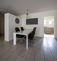 Dining room with leather chairs and open door to the kitchen
