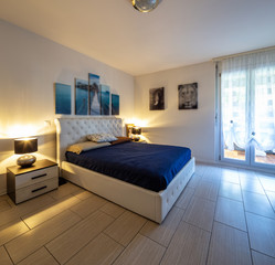 Bedroom with lighted lamps and paintings on the walls