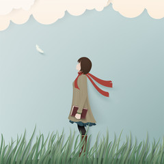 Alone girl in winter coat on green grass with book.Paper art concept background.
