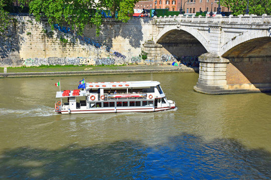 Rome,  a large boat transports tourists to the Tiber River.
