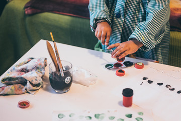 Una niña juega con pinturas y temperas