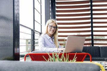 Elegant and cheerful businesswoman in modern office