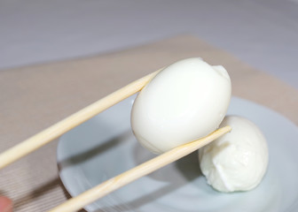箸でつまんだ茹で卵