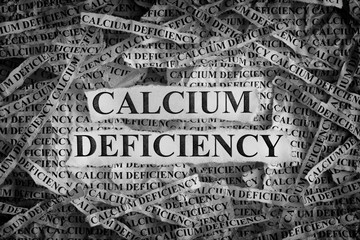 Torn pieces of paper with the words Calcium Deficiency