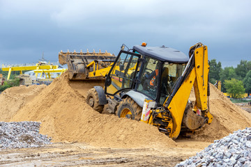 A bulldozer rakes the sand in a heap