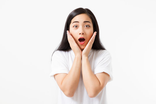 Surprised shocked excited asian woman face isolated on white background. Young asian girl in summer t shirt. Copy space