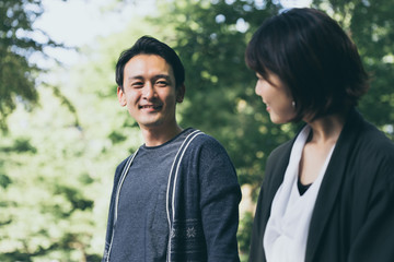 Fototapeta premium 新緑の下で彼女の見つめる男性