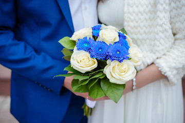 Wedding bouquet close up in the hands of the bride and groom