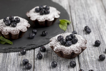 Cake with blueberry and sugar powder on the table.