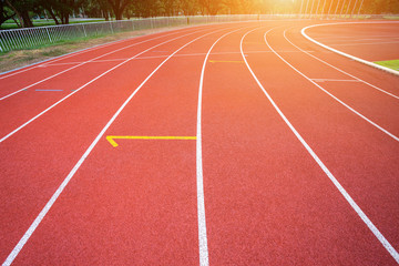 White lines of stadium and texture of running racetrack red rubber racetracks in outdoor stadium are 8 track and green grass field,empty athletics stadium with track.