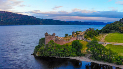 Fototapeta na wymiar Urquhart Castle at famous Lake Loch Ness in the evening - aerial view