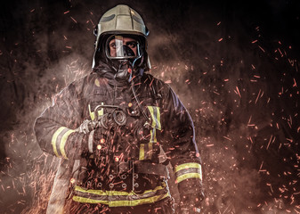 A firefighter dressed in a uniform in a studio.