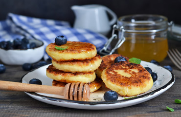Classic Russian breakfast - cheesecake with honey and berries.