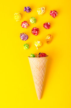 Sweet colored popcorn on bright background