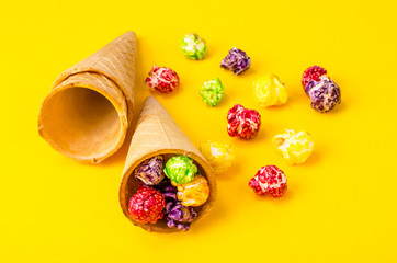 Sweet colored popcorn on bright background