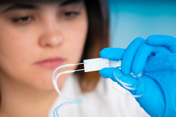 technician girl with microfluidic device LOC in microbiological lab