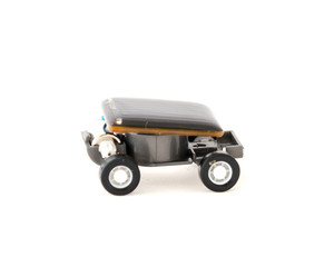 Studio shot educational solar powered toy car isolated on white. Mini solar cells panel at the top roof