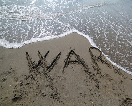 word war written on the sand of the beach erased from the water