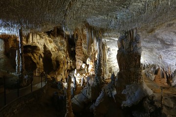 Postojna cave, Slovenia. Formations inside cave with stalactites and stalagmites. People travel by entertainment train in Postojna Cave. it is one of top Slovenian tourism sites