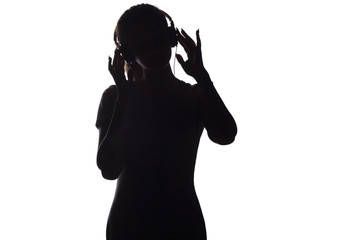 silhouette of a woman listening to music in headphones on a white isolated background