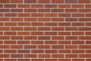 Reddish brown brick wall background in traditional running bond pattern