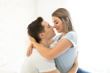 Passionate Couple About To Kiss In Brightly Lit Bedroom