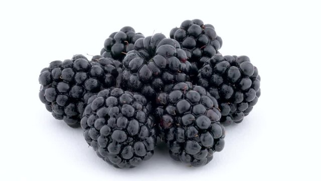 Heap of blackberries rotating on the on the turntable isolated on the white background. Close up.