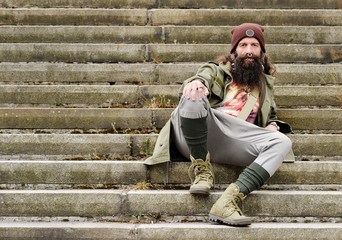 fashionable bearded man waiting on stairs