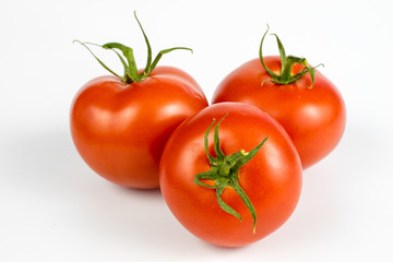 Red tomatoes on a white table. Tasty vegetables for the best dishes in the kitchen.