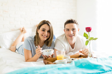 Obraz na płótnie Canvas Smiling Girlfriend And Boyfriend Having Healthy Breakfast In Bed