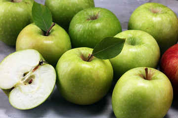 Ripe red apples with leaves on wooden background.
