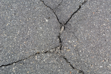 Old Asphalt covering with cracks. Gray neglected background