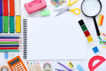 School supplies with blank sheet of paper on wooden table