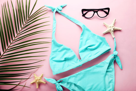 Blue swimsuit with green palm leaf and starfishes on pink background