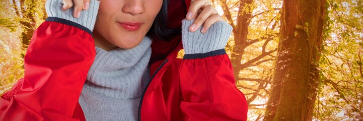 Composite image of smiling woman in hooded jacket standing